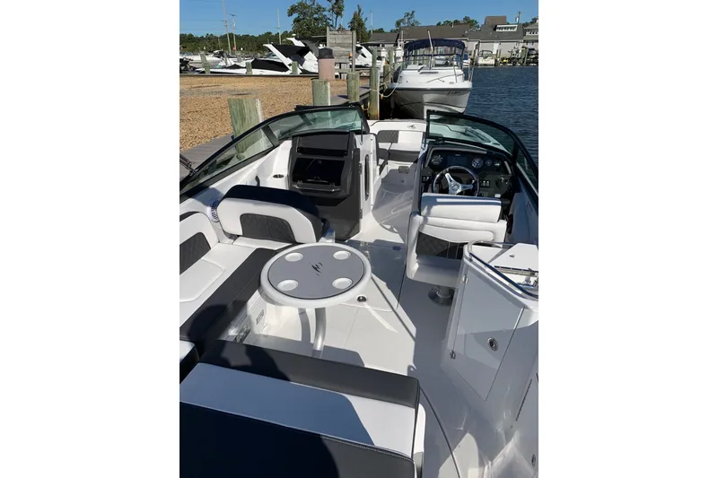 Slide: The Image of 2021 Monterey M-45 boat interior with seating and steering, docked at a marina. - 5