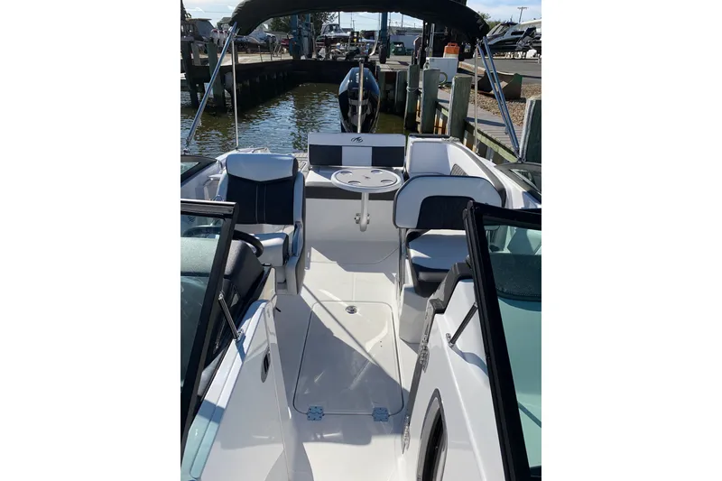 Slide: The Image of 2021 Monterey M-45 boat interior with seating and table, docked by the water. - 3