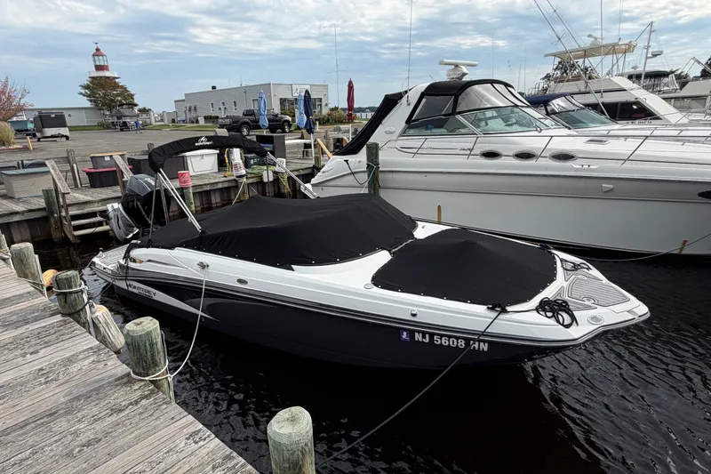 Slide: The Image of 2021 Monterey M-45 boat docked at marina with black cover, lighthouse in background. - 46