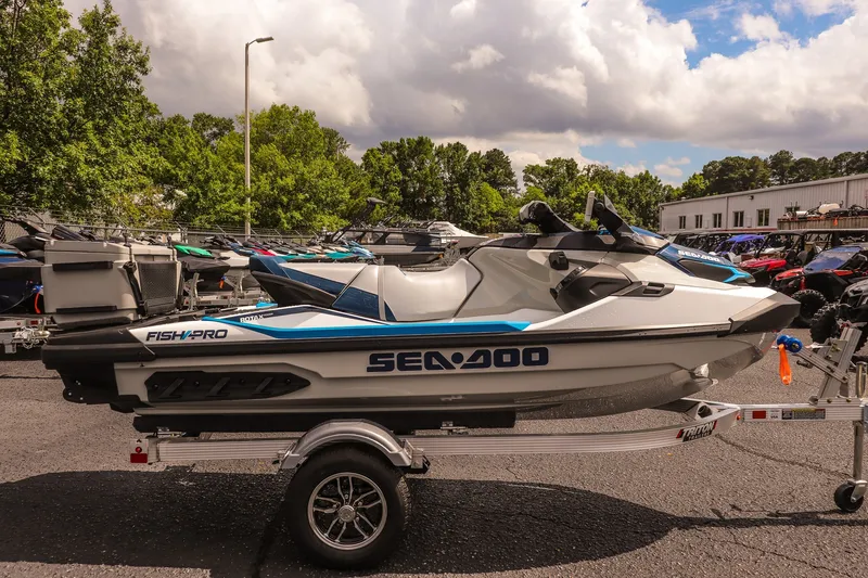 Slide: The Image of 2026 Sea-Doo FishPro Sport 170 jet ski on trailer, parked outdoors under cloudy sky. - 4