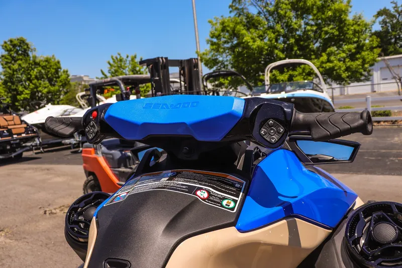 Slide: The Image of 2026 Sea-Doo Wake 170 handlebars and controls, parked outdoors on a sunny day. - 10