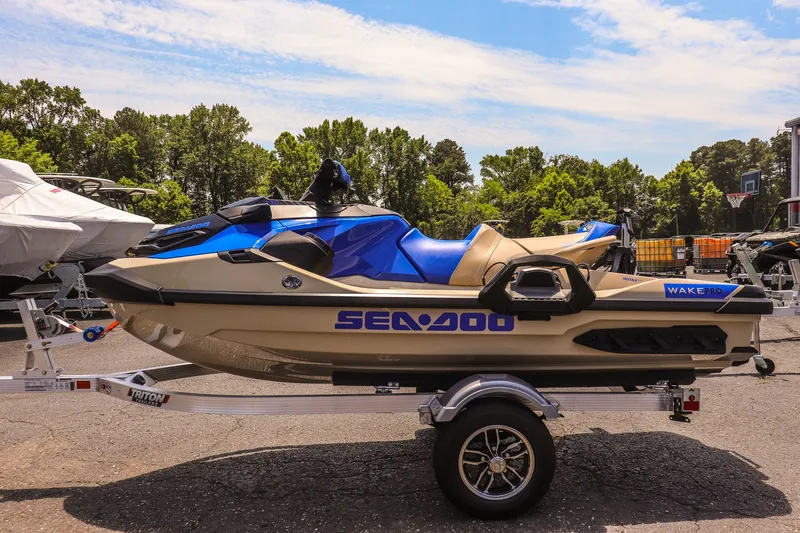 Slide: The Image of 2026 Sea-Doo Wake Pro 230 jet ski on trailer, parked outdoors under clear sky. - 6