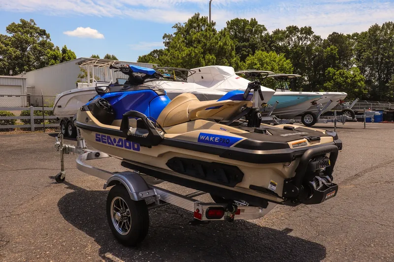Slide: The Image of 2026 Sea-Doo Wake Pro 230 jet ski on trailer, parked outdoors near boats. - 5