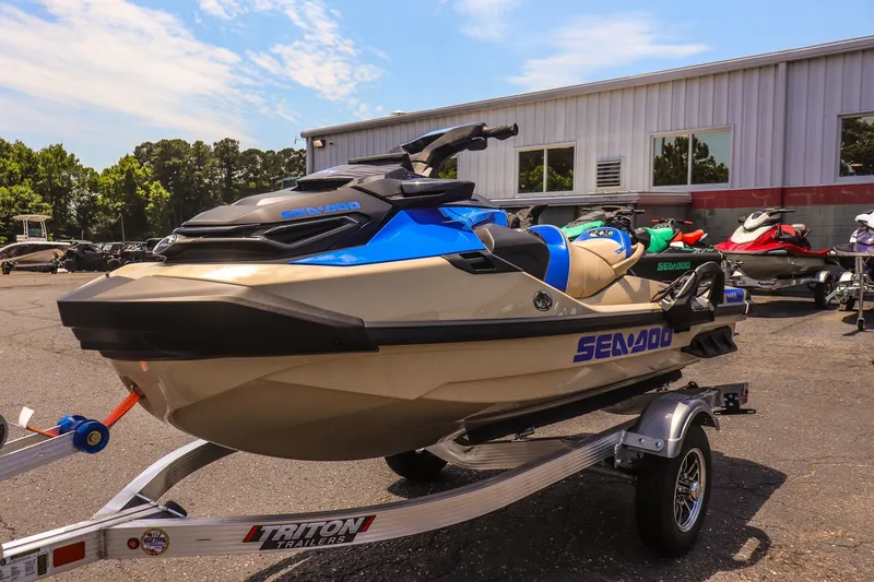 Slide: The Image of 2026 Sea-Doo Wake Pro 230 jet ski on trailer, parked outdoors near a building. - 7