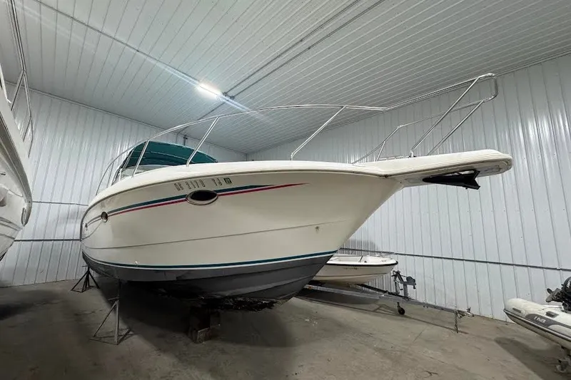 Slide: The Image of 1994 Silverton 310 Express boat in indoor storage, showcasing sleek design and sturdy build. - 2