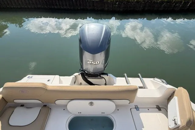 Slide: The Image of 2019 Key West 239 FS boat with 250 HP engine, docked on calm water. - 14