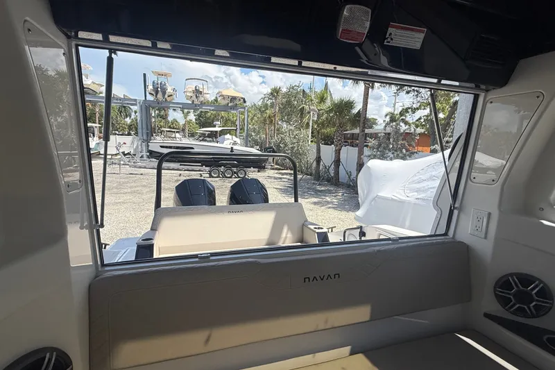 Slide: The Image of Interior view of 2026 Navan C30 boat, showcasing seating and outdoor marina scene. - 20