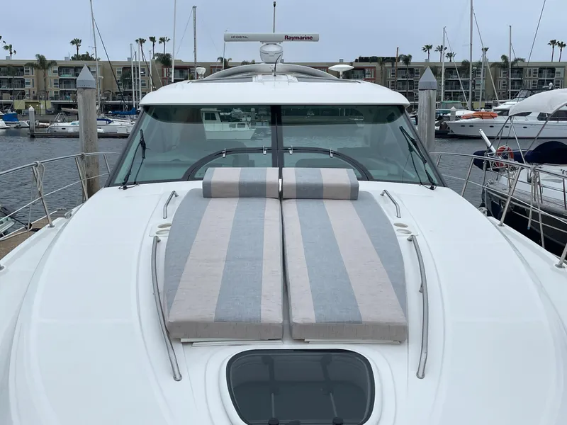 Slide: The Image of The 2012 Sea Ray 470 Sundancer is docked, featuring a large striped sun deck. - 25