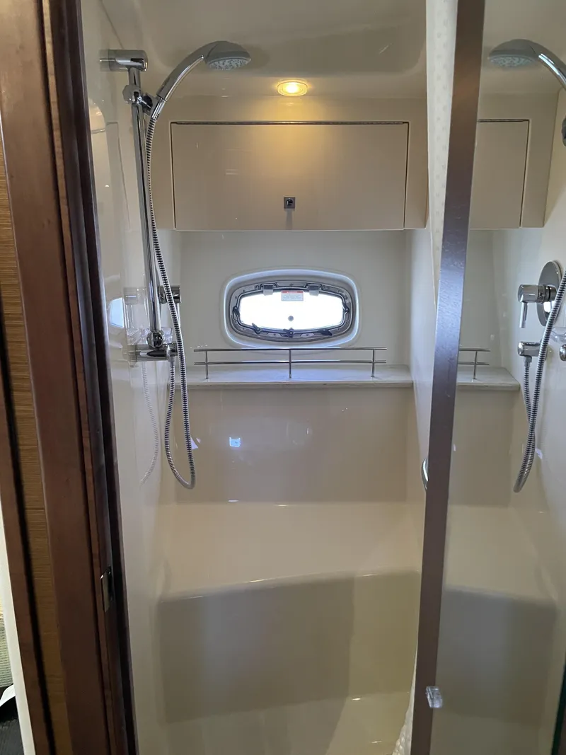 Slide: The Image of The shower in a 2012 Sea Ray 470 Sundancer features a glass wall and a window. - 38