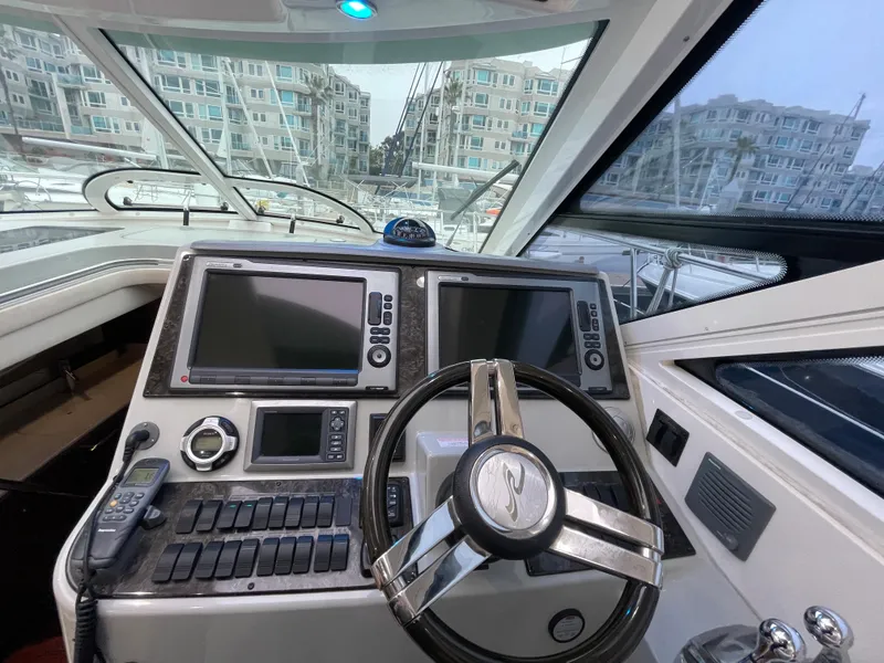 Slide: The Image of The cockpit of the 2012 Sea Ray 470 Sundancer features a modern helm with two large screens. - 19