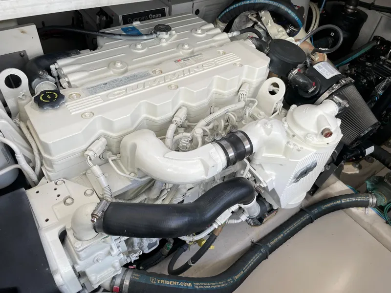 Slide: The Image of The engine room of a 2012 Sea Ray 470 Sundancer features a large white engine with hoses. - 50