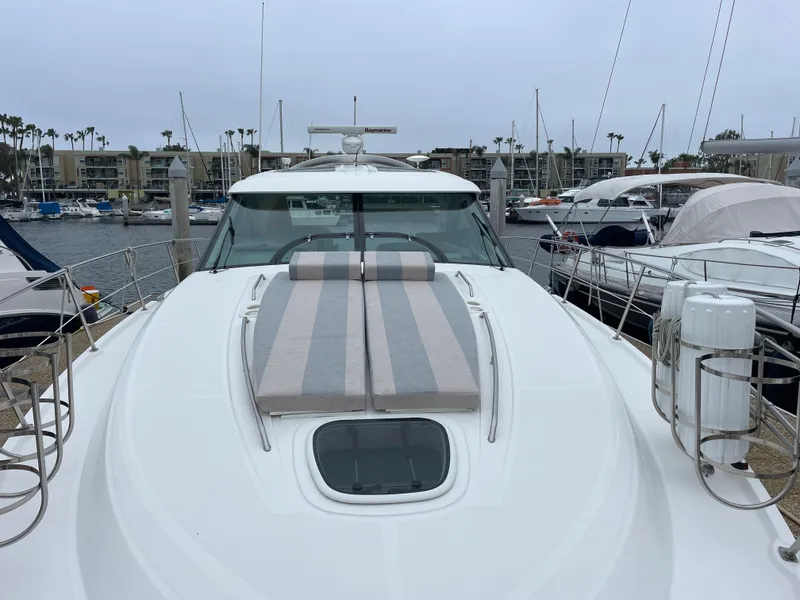 Slide: The Image of The 2012 Sea Ray 470 Sundancer is docked, featuring a large sun deck and surrounded by other boats. - 24