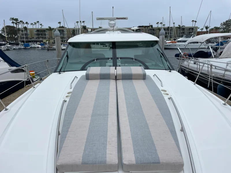 Slide: The Image of The 2012 Sea Ray 470 Sundancer features a sleek foredeck with striped sun loungers. - 26
