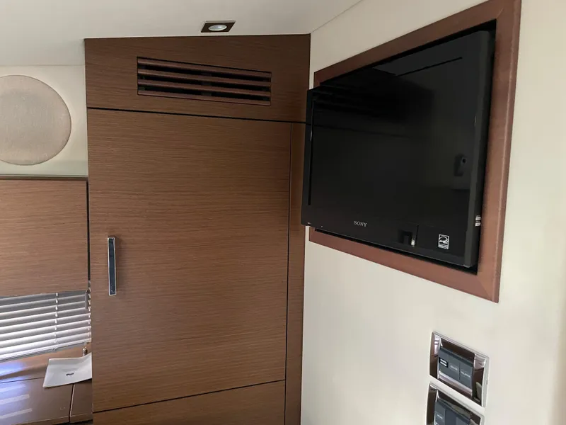 Slide: The Image of Interior of the 2012 Sea Ray 470 Sundancer with a flat-screen TV mounted on the wall. - 36