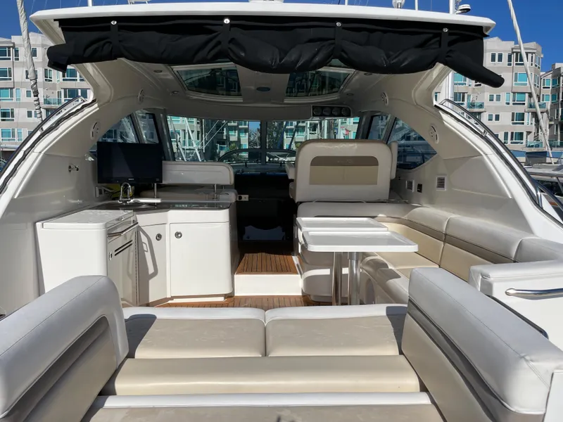 Slide: The Image of The image shows the cockpit of a 2012 Sea Ray 470 Sundancer with sleek white seating and a table. - 14