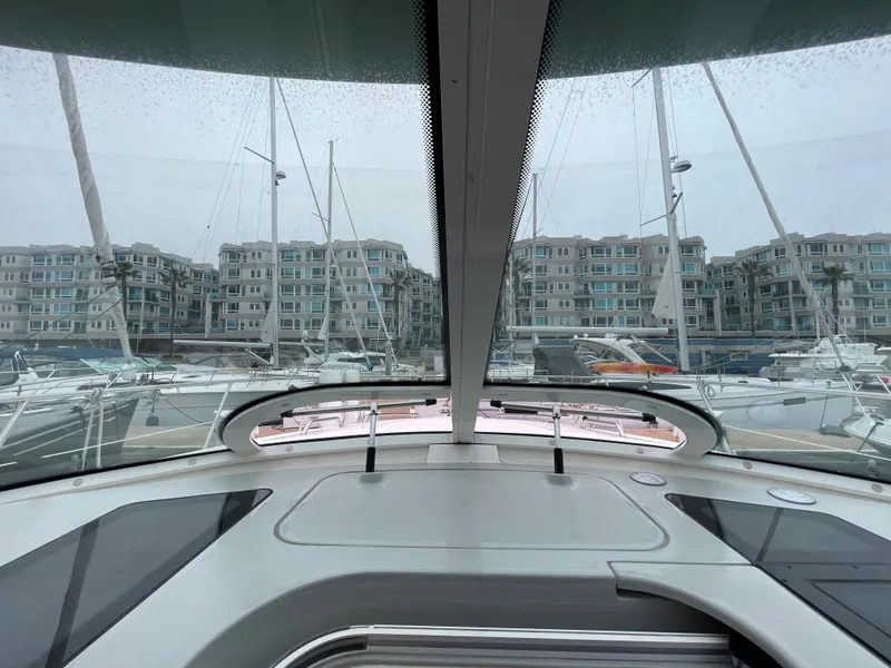 Slide: The Image of View from the cockpit of a Sea Ray 470 Sundancer overlooking a marina with several boats and buildings. - 18