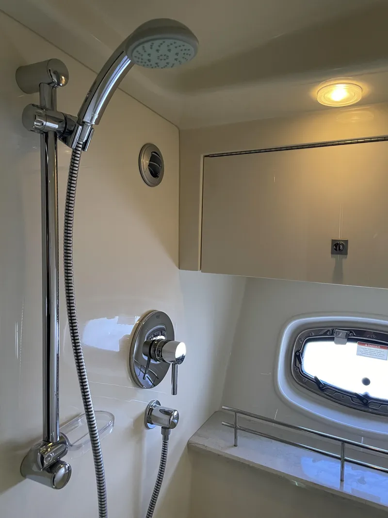 Slide: The Image of The 2012 Sea Ray 470 Sundancer shower features chrome fixtures and a porthole. - 39