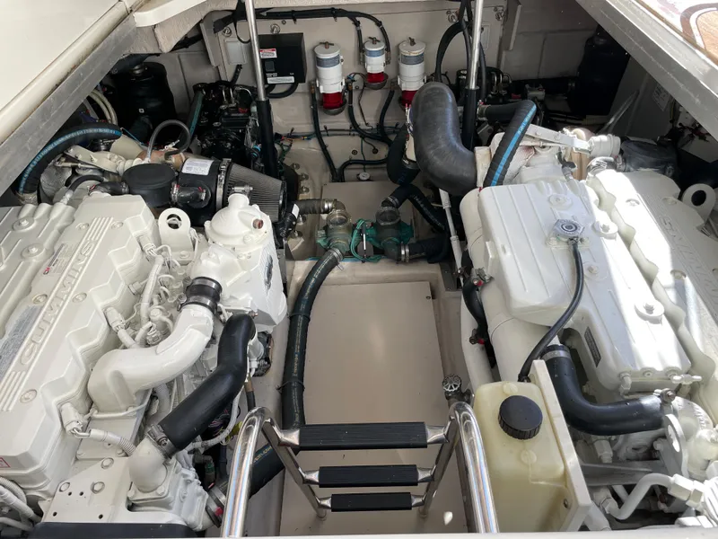 Slide: The Image of The engine room of a 2012 Sea Ray 470 Sundancer features two large engines and various hoses. - 47
