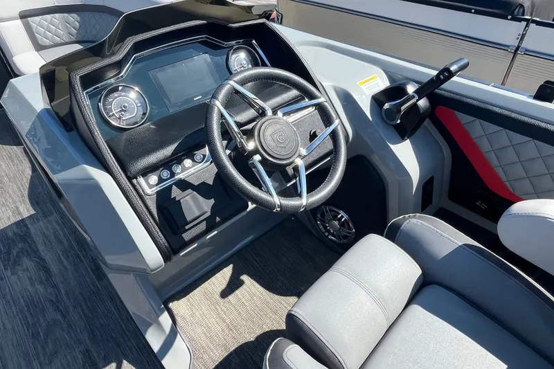 Slide: The Image of Interior of 2022 Godfrey AquaPatio 235 ULC boat, featuring modern steering and dashboard controls. - 7