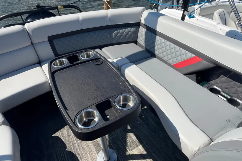 Slide: The Image of Luxurious seating area on 2022 Godfrey AquaPatio 235 ULC pontoon boat with cup holders. - 11