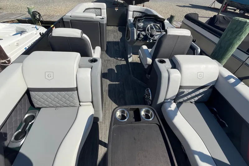 Slide: The Image of 2022 Godfrey AquaPatio 235 ULC pontoon boat interior with luxurious seating and modern dashboard. - 15