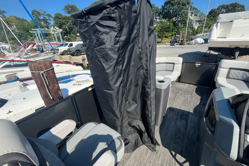Slide: The Image of 2022 Godfrey AquaPatio 235 ULC boat interior with seating and privacy curtain. - 13