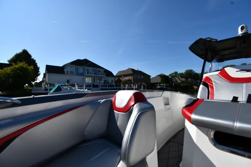 Slide: The Image of 2017 Sunsation 32 CCX boat interior with modern seating, docked near waterfront homes. - 23