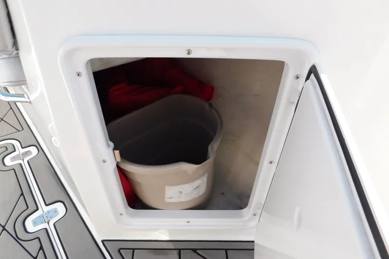 Slide: The Image of Storage compartment on a 2017 Sunsation 32 CCX boat with a bucket inside. - 16