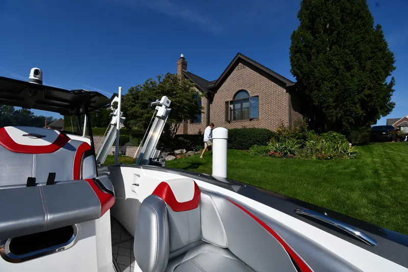Slide: The Image of 2017 Sunsation 32 CCX boat parked near a brick house with lush greenery. - 22