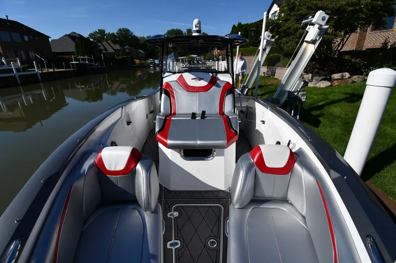 Slide: The Image of 2017 Sunsation 32 CCX boat with sleek seating, docked by a canal. - 8