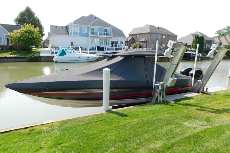 Slide: The Image of 2017 Sunsation 32 CCX boat covered and docked in a residential canal setting. - 52