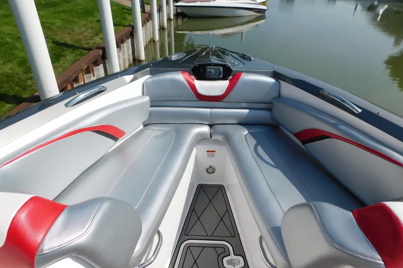 Slide: The Image of 2017 Sunsation 32 CCX boat interior with sleek silver and red seating, docked by the water. - 17