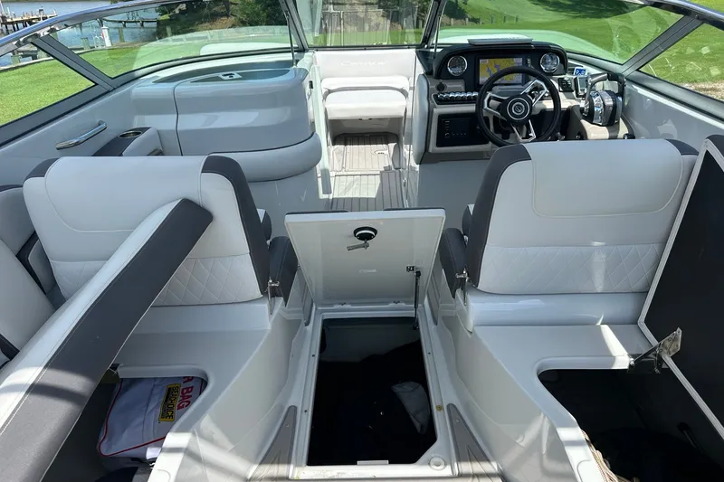 Slide: The Image of 2021 Crownline Eclipse E305 XS boat interior with open storage compartments and modern dashboard. - 20