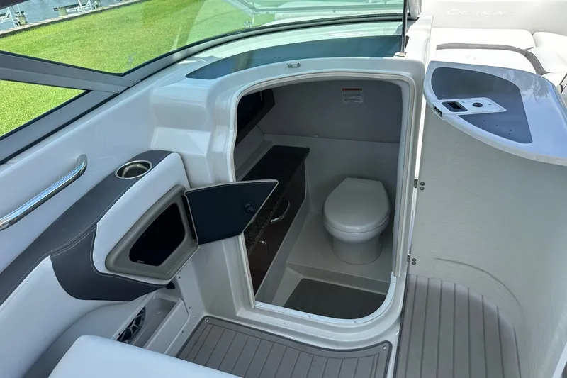 Slide: The Image of 2021 Crownline Eclipse E305 XS boat interior with compact bathroom and seating area. - 28