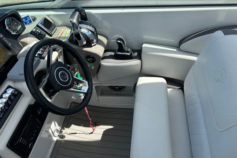 Slide: The Image of 2021 Crownline Eclipse E305 XS boat cockpit with steering wheel and controls. - 23