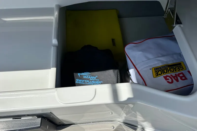 Slide: The Image of Storage compartment in a 2021 Crownline Eclipse E305 XS boat with safety gear. - 21