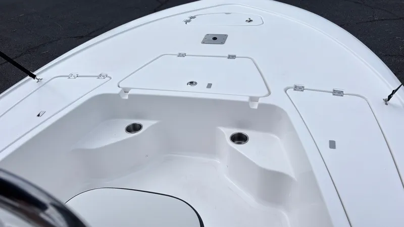 Slide: The Image of The image shows the deck of a 2024 Tidewater 1910 Bay Max boat with storage and cup holders. - 13