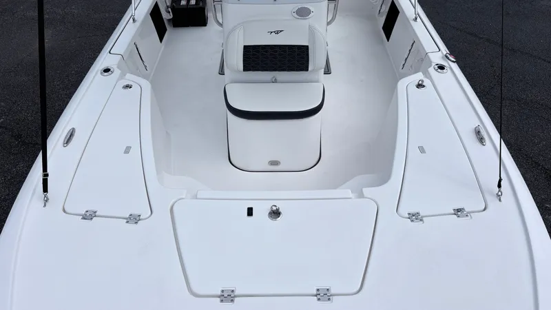 Slide: The Image of The image shows the deck of a 2024 Tidewater 1910 Bay Max boat with white upholstery and storage. - 18