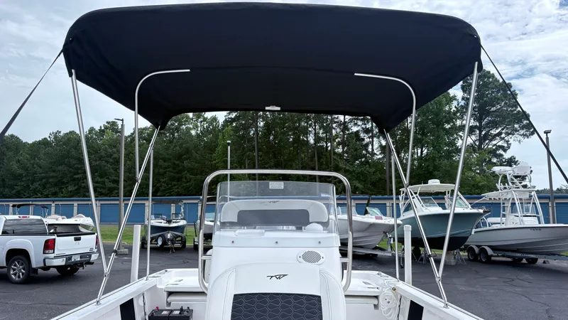 Slide: The Image of The image shows a 2024 Tidewater 1910 Bay Max boat with a black sunshade outdoors. - 19