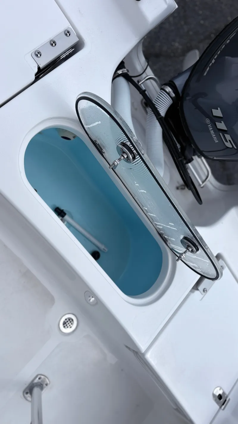 Slide: The Image of An open storage compartment on a 2024 Tidewater 1910 Bay Max boat, featuring a blue interior. - 9