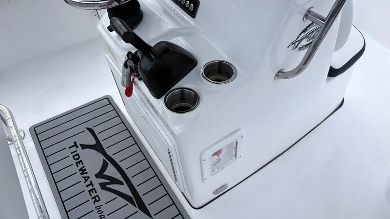 Slide: The Image of The image shows the cockpit of a Tidewater 1910 Bay Max boat with cup holders and a floor mat. - 12