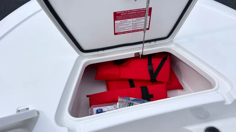 Slide: The Image of An open storage compartment on a boat reveals red life jackets and other safety equipment. - 15