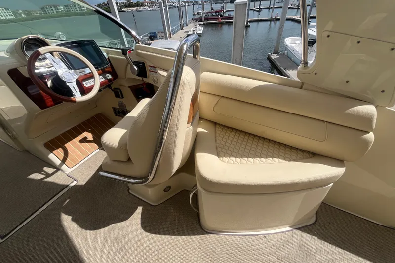 Slide: The Image of 2019 Chris-Craft Launch GT 28 helm with beige seating and wooden accents at marina. - 17