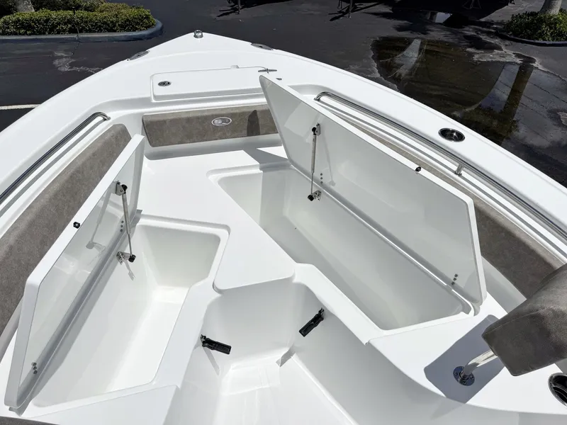 Slide: The Image of The image shows the bow of a Sea Hunt Ultra 229 boat with open storage compartments. - 26