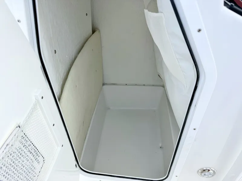 Slide: The Image of Interior of a Sea Hunt Ultra 229 boat, showing an empty, white storage compartment. - 22
