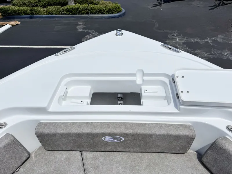 Slide: The Image of The image shows the bow of a Sea Hunt Ultra 229 boat with gray cushions and storage space. - 29