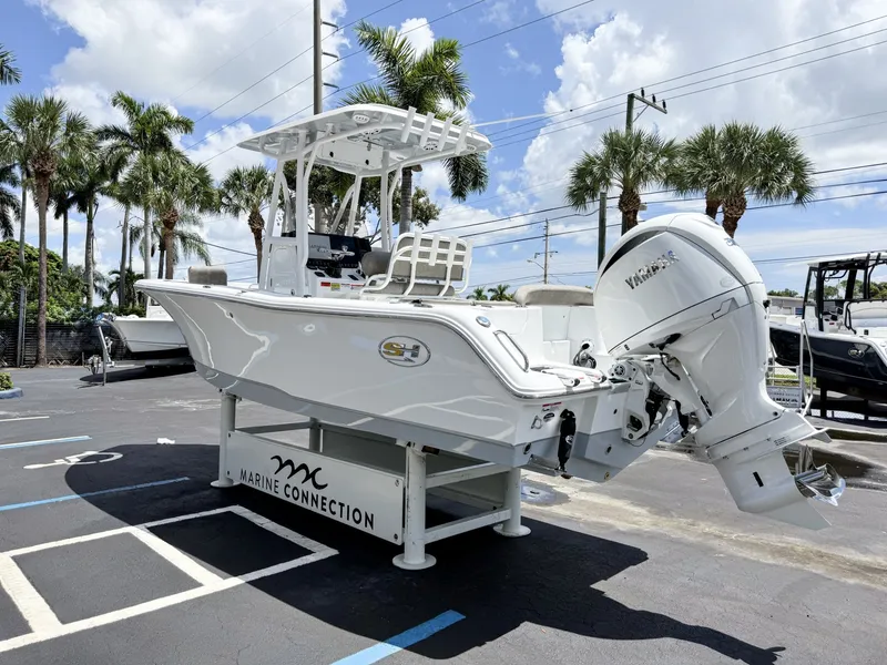 Slide: The Image of A 2027 Sea Hunt Ultra 229 boat on a trailer in a parking lot, surrounded by palm trees. - 6