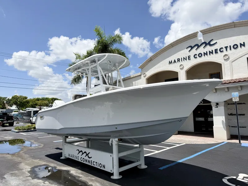 Slide: The Image of A 2027 Sea Hunt Ultra 229 boat is on a stand outside a building labeled "Marine Connection." - 2