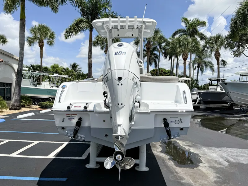 Slide: The Image of A 2027 Sea Hunt Ultra 229 boat is parked, surrounded by palm trees. - 7