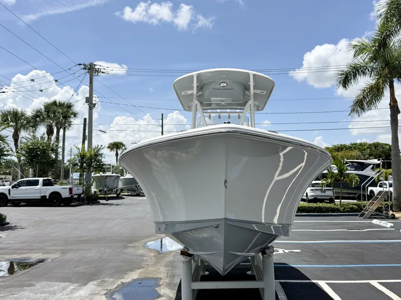 Slide: The Image of A 2027 Sea Hunt Ultra 229 boat is parked on a lot under a blue sky. - 3